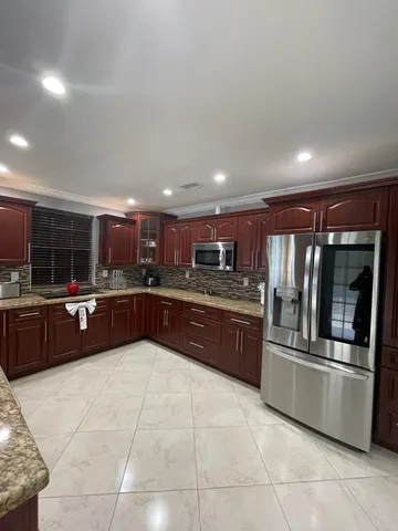 a large kitchen with a large counter top and stainless steel appliances