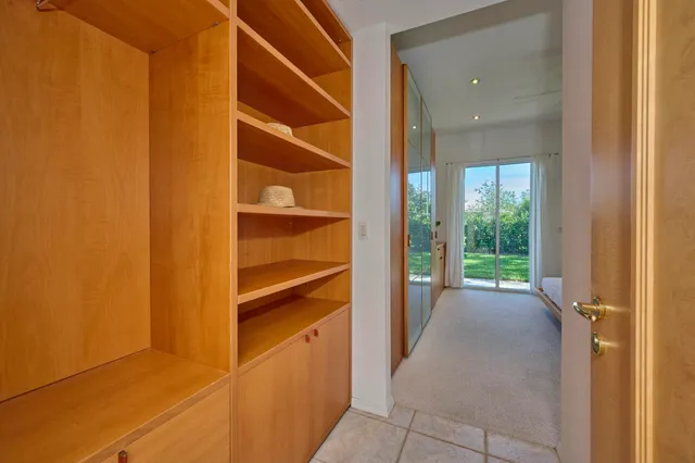 a bed sitting in a spacious bedroom next to a window