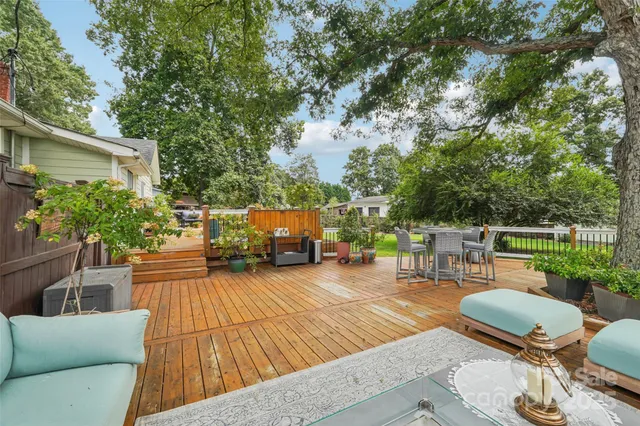 a view of a patio with table and chairs potted plants and a large tree