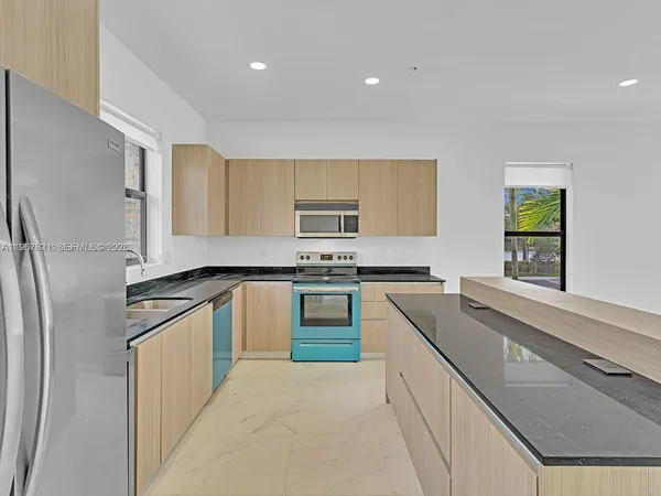 a kitchen with granite countertop stainless steel appliances and white cabinets