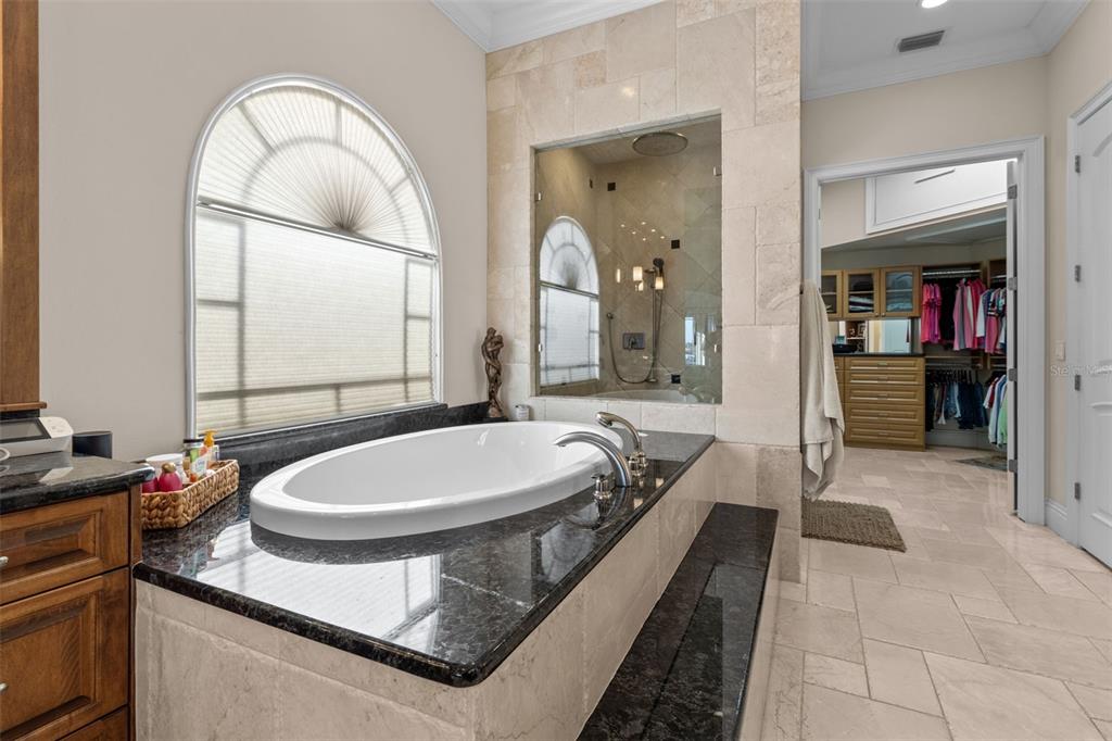 7986 9th Avenue South St. Petersburg, FL 33707 - Photo 27 of 83 a bathroom with a granite countertop sink a mirror and a bathtub
