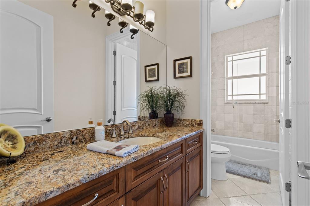 7986 9th Avenue South St. Petersburg, FL 33707 - Photo 44 of 83 a bathroom with a granite countertop sink a toilet and bathtub