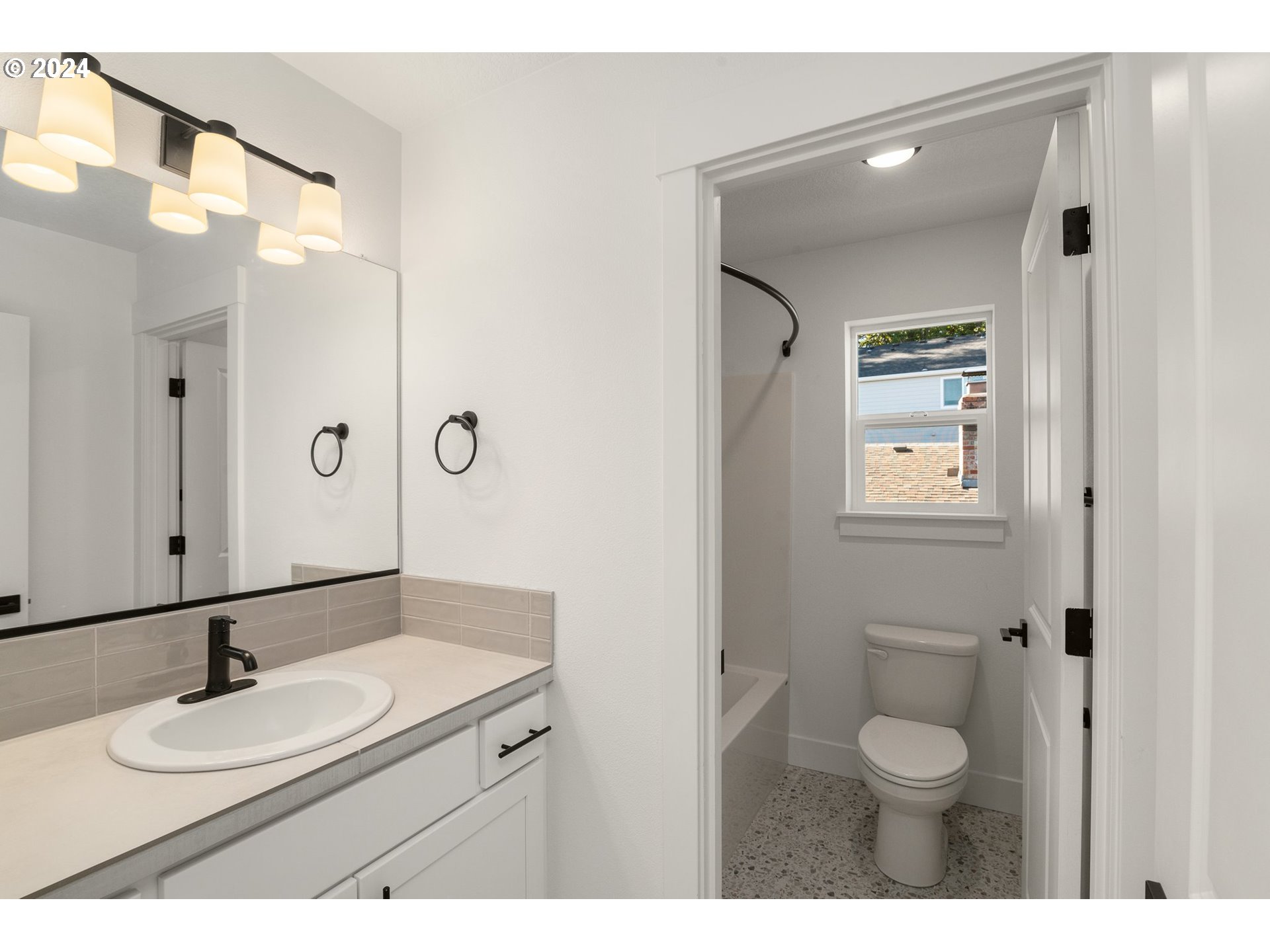 7939 Southwest 176th Terrace, Unit LOT1 Beaverton, OR 97007 - Photo 20 of 25 a bathroom with a granite countertop sink toilet a mirror and shower