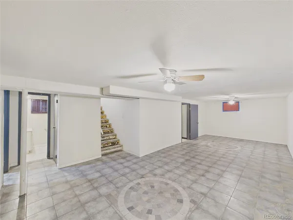 an empty room with a ceiling fan and window