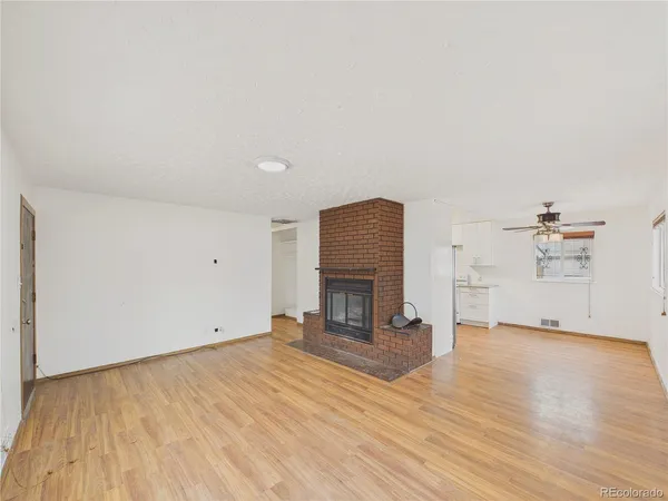 an empty room with wooden floor and fireplace