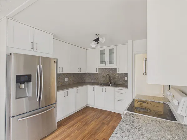 a kitchen with granite countertop a refrigerator and a sink