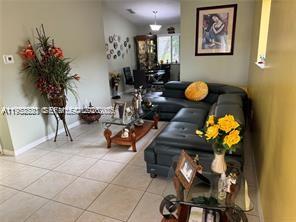 1250 Southeast 28th Court, Unit 206 Homestead, FL 33035 - Photo 12 of 26 a living room with furniture and flowers