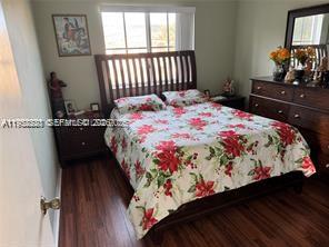 1250 Southeast 28th Court, Unit 206 Homestead, FL 33035 - Photo 15 of 26 a bedroom with a bed and wooden floor