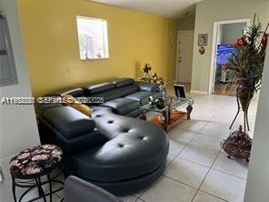 1250 Southeast 28th Court, Unit 206 Homestead, FL 33035 - Photo 7 of 26 a living room with furniture and flowers