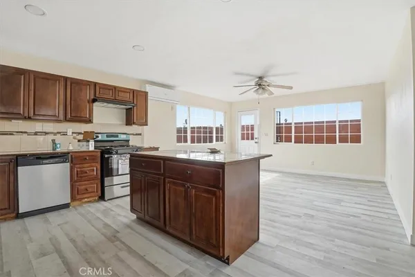 a kitchen with stainless steel appliances granite countertop a stove cabinets and wooden floor