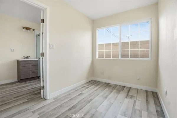 an empty room with wooden floor and a window