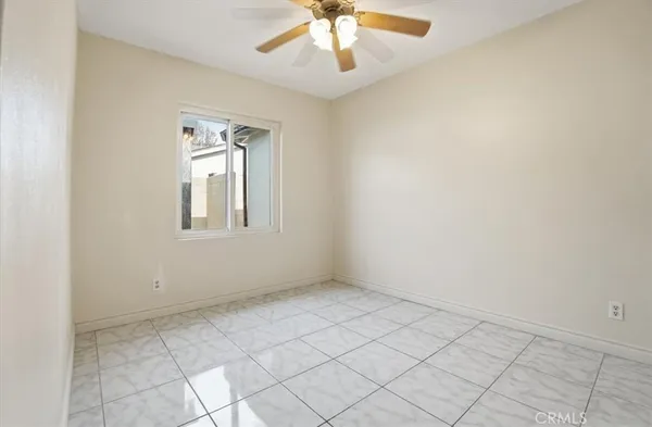 an empty room with chandelier fan