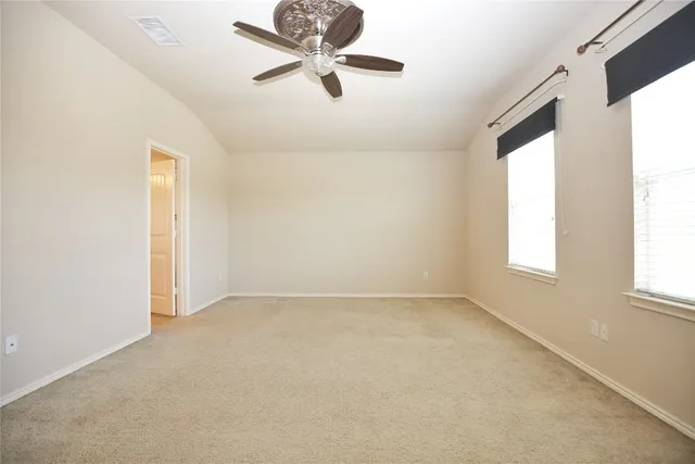 an empty room with windows and fan