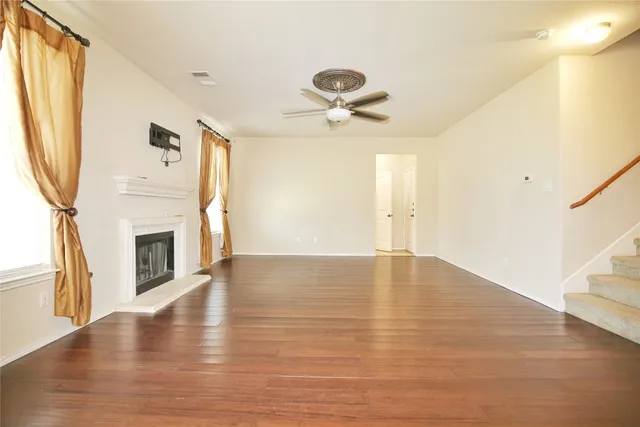 a view of empty room with wooden floor and fireplace