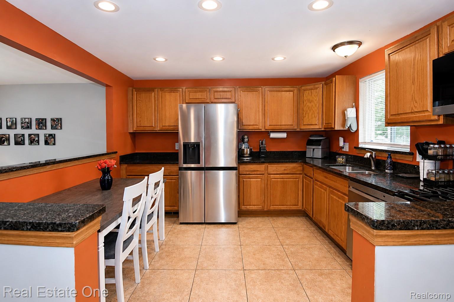 15404 Colbert Street Romulus, MI 48174 - Photo 5 of 23 Kitchen featuring warm wood cabinetry, dark granite countertops, stainless steel appliances, and tile flooring