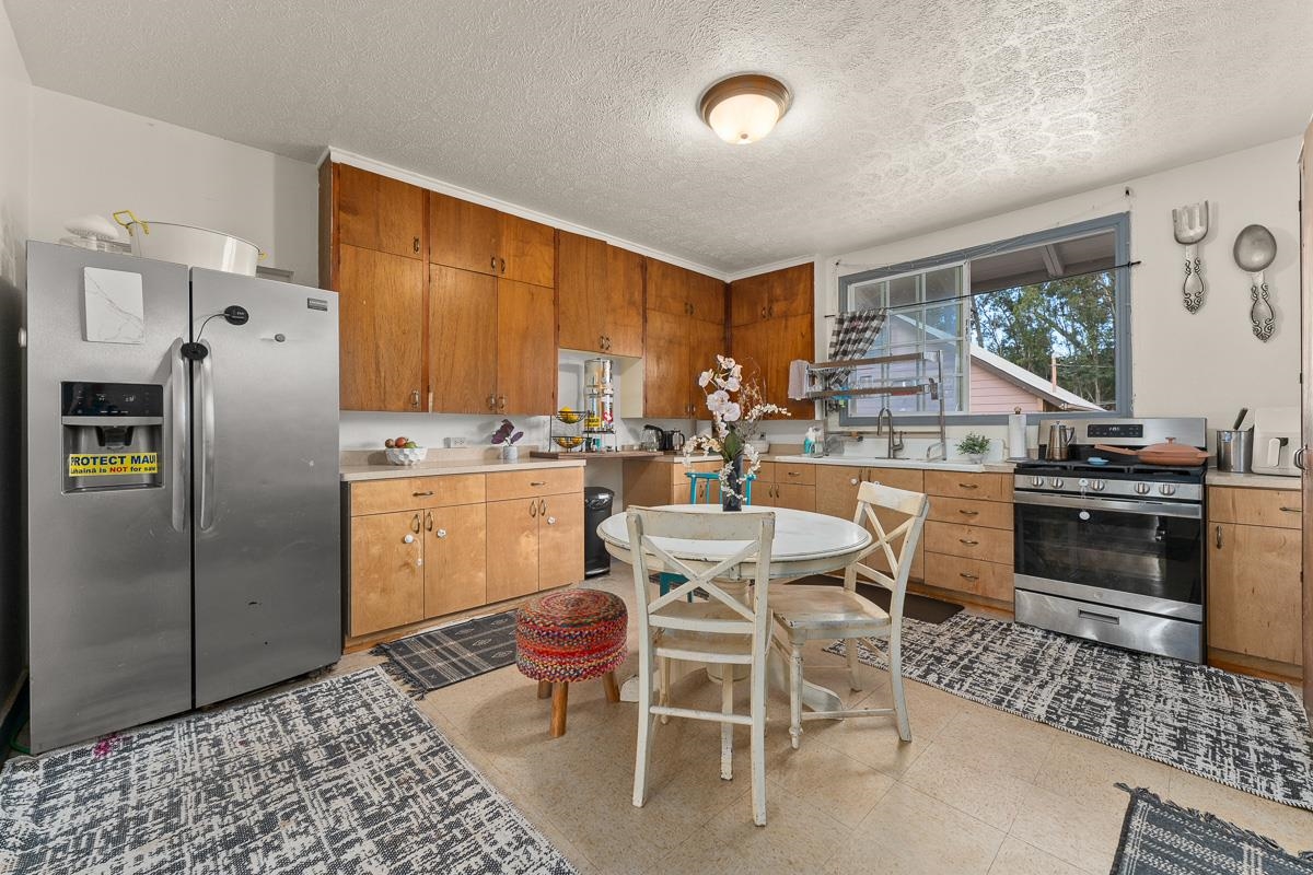 2970 Kailiili Road, Unit 1B Haiku, HI 96708 - Photo 8 of 47 a kitchen with a table chairs microwave and refrigerator