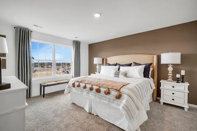 a spacious bedroom with a bed and a large window