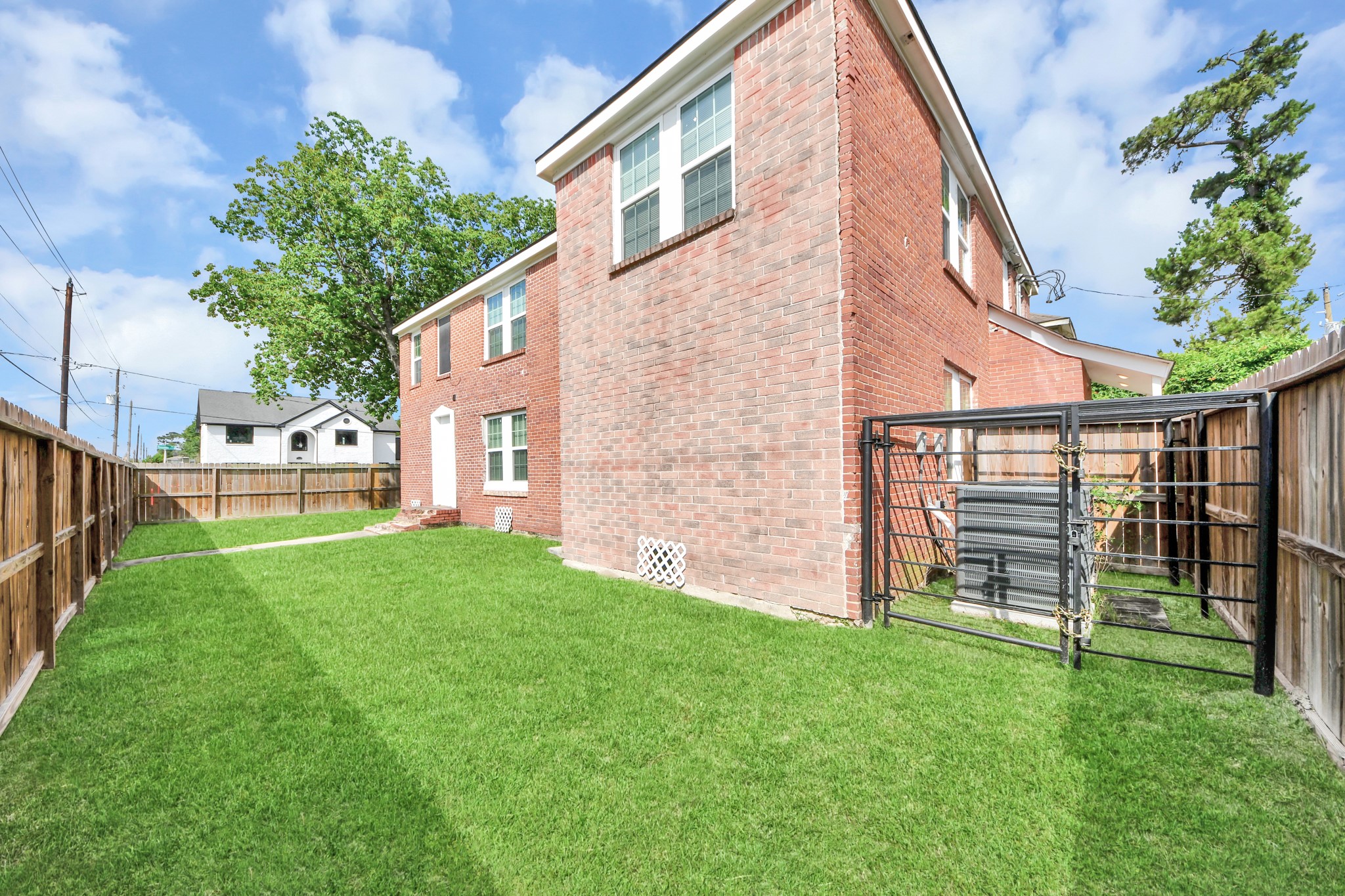 2919 Rosedale Street, Unit B Houston, TX 77004 - Photo 35 of 35 a view of a backyard with plants and large trees