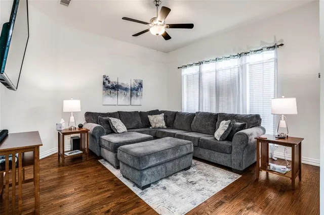 a living room with furniture and a wooden floor