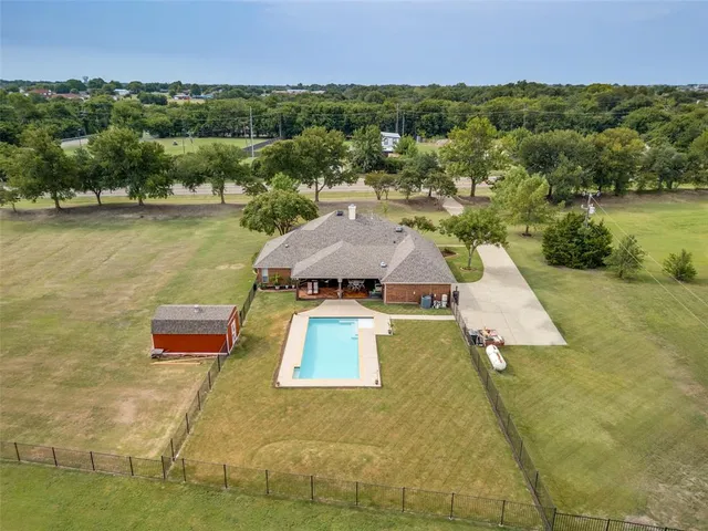 an aerial view of a house with a yard and lake view