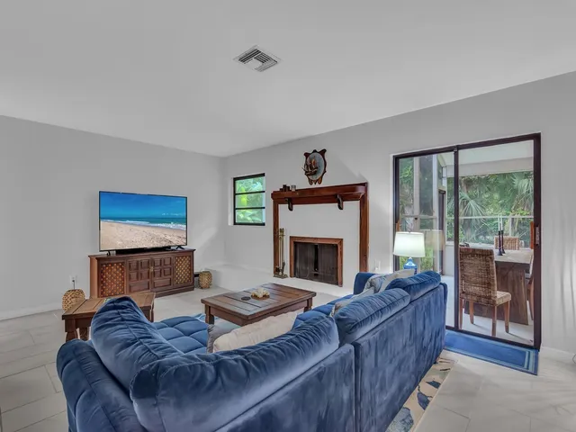 a living room with furniture a fireplace and a floor to ceiling window