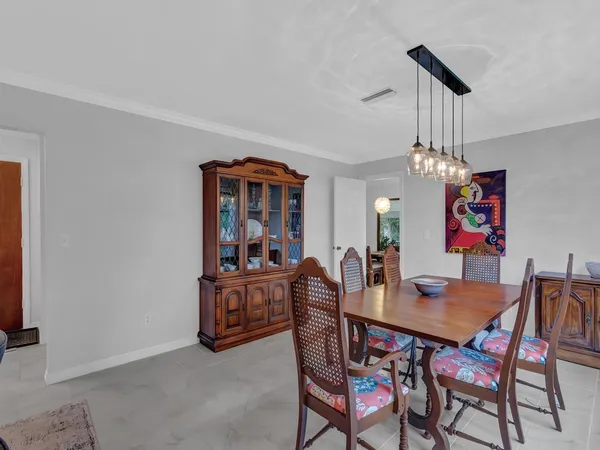 a dining room with furniture a chandelier and wooden floor