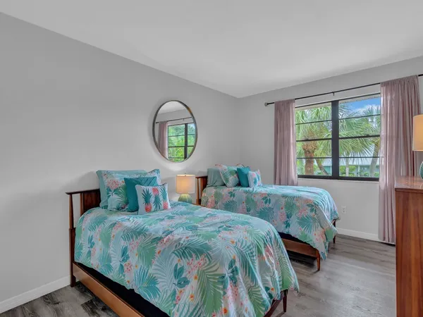 a bedroom with two beds and a window