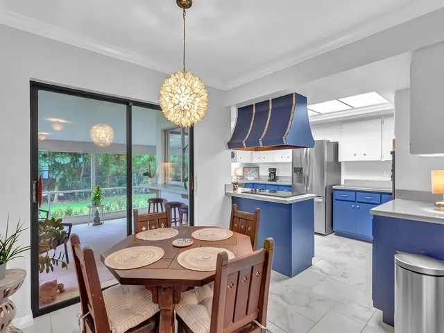 a view of a dining room with furniture a chandelier and wooden floor