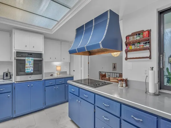 a kitchen with granite countertop a sink a stove and cabinets