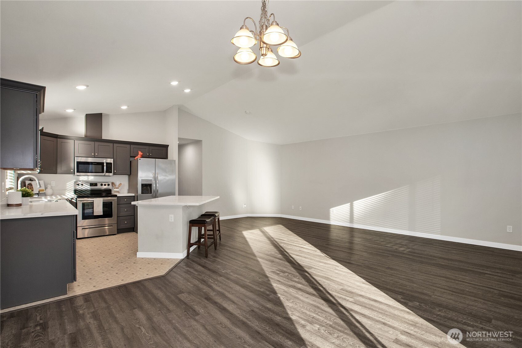 17643 Loop Lane Southeast Yelm, WA 98597 - Photo 11 of 34 a view of a kitchen with granite countertop wooden floor stainless steel appliances and a chandelier