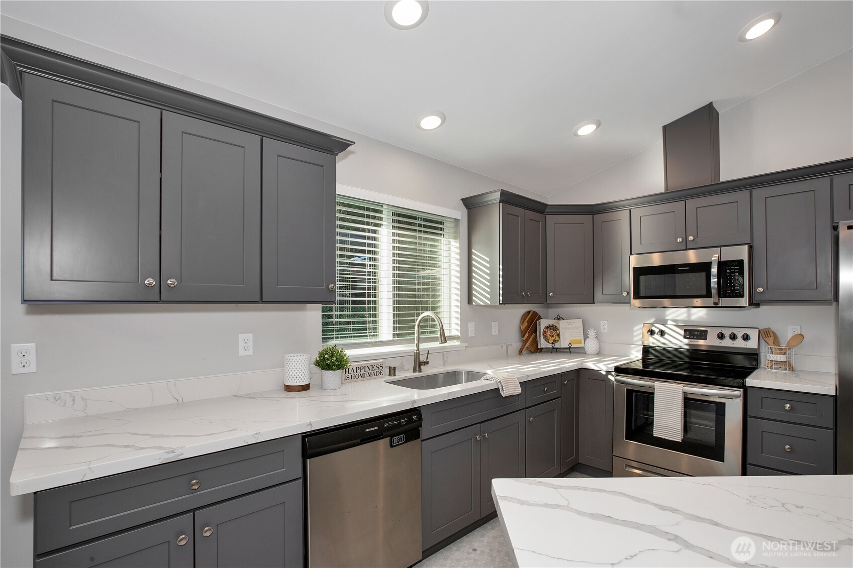 17643 Loop Lane Southeast Yelm, WA 98597 - Photo 12 of 34 a kitchen with stainless steel appliances granite countertop a sink a stove a microwave a sink a refrigerator and cabinets