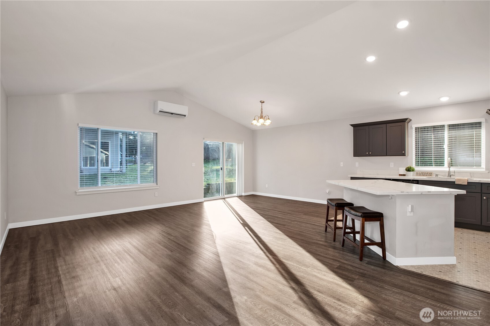 17643 Loop Lane Southeast Yelm, WA 98597 - Photo 9 of 34 a view of a kitchen with kitchen island a sink dishwasher a dining table and chairs with wooden floor