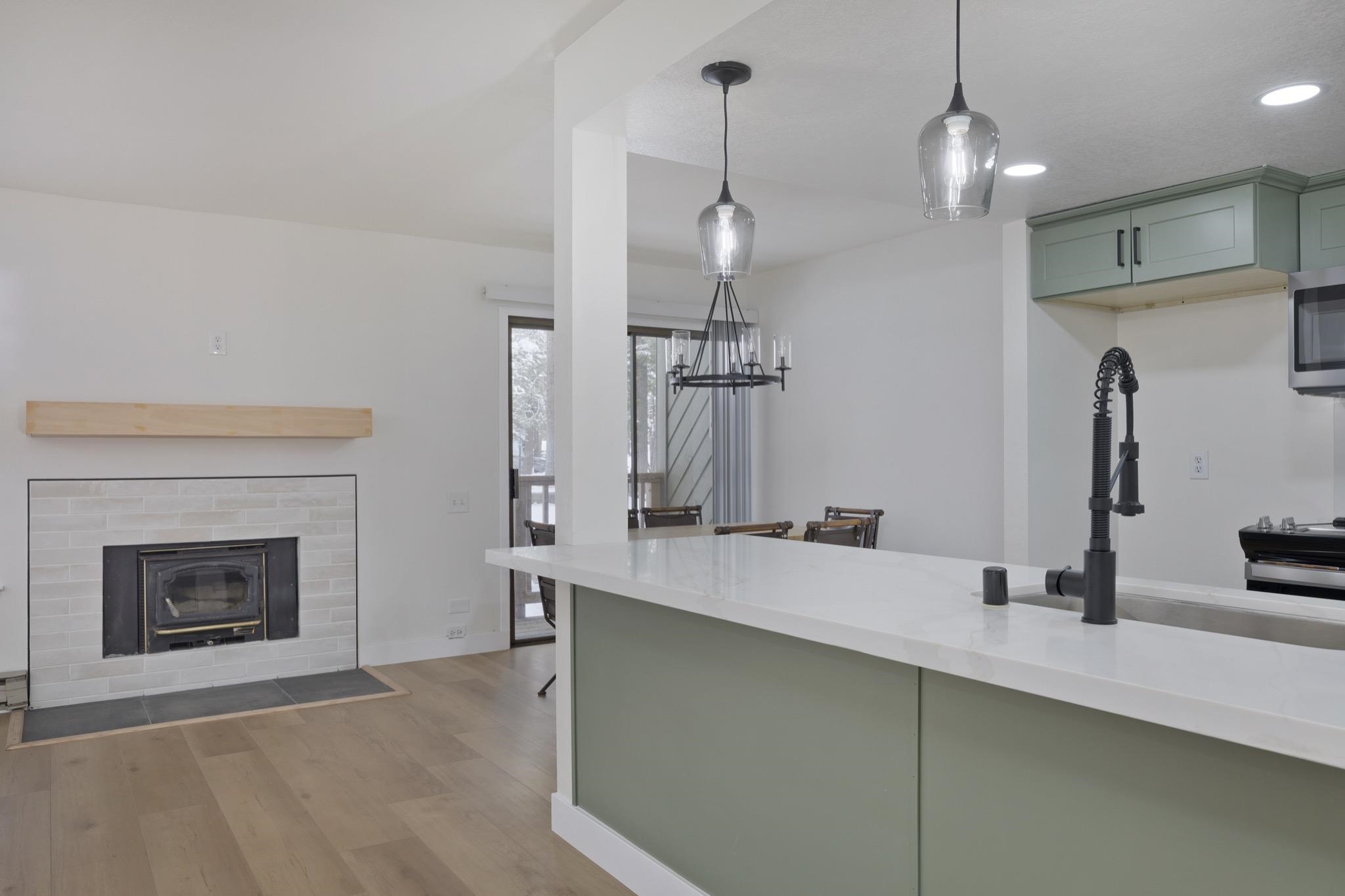 152 Viewpoint Road, Unit 105 Mammoth Lakes, CA 93546 - Photo 11 of 29 a kitchen with kitchen island a sink stainless steel appliances and a fireplace