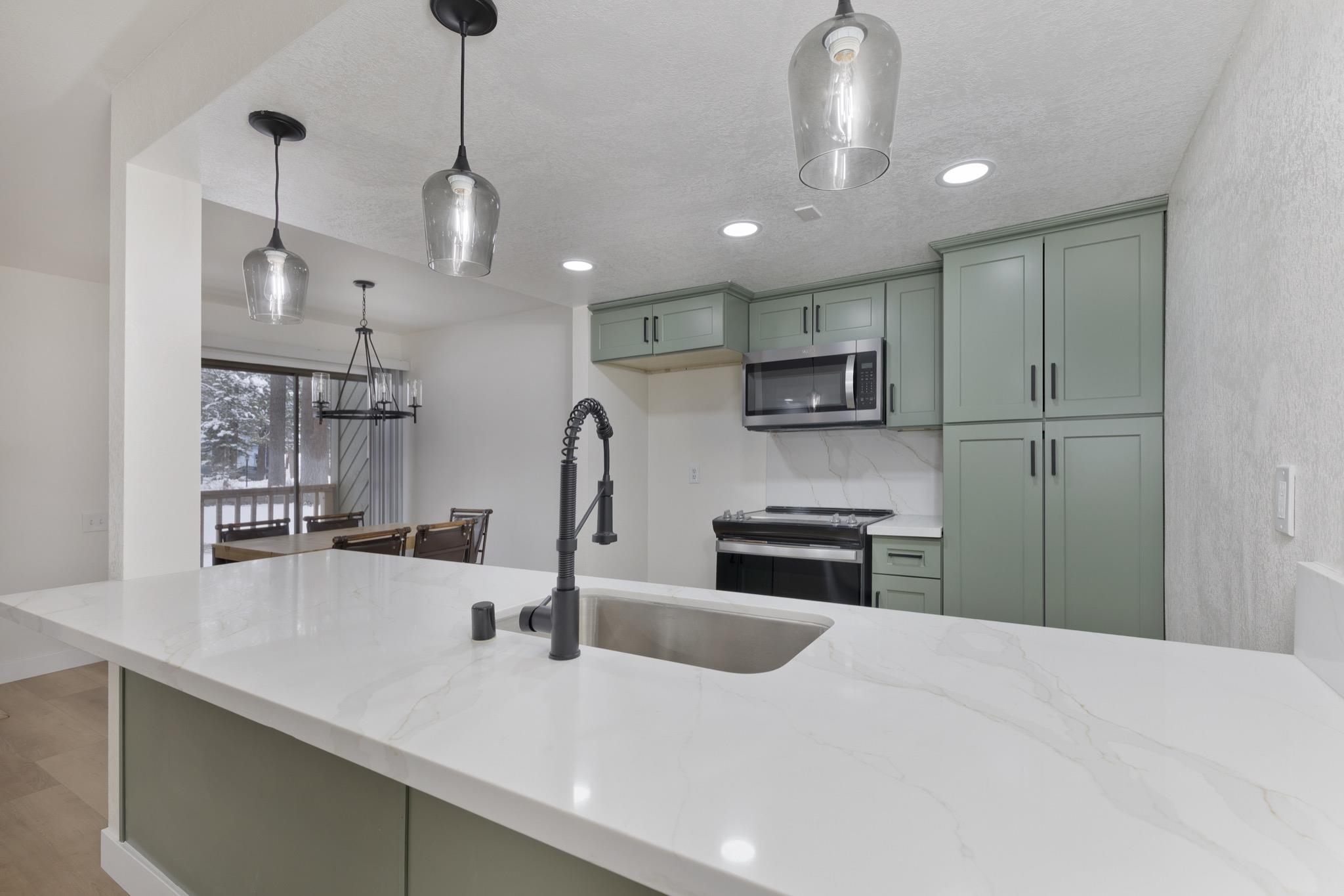 152 Viewpoint Road, Unit 105 Mammoth Lakes, CA 93546 - Photo 12 of 29 a kitchen with stainless steel appliances granite countertop a sink a stove and a refrigerator