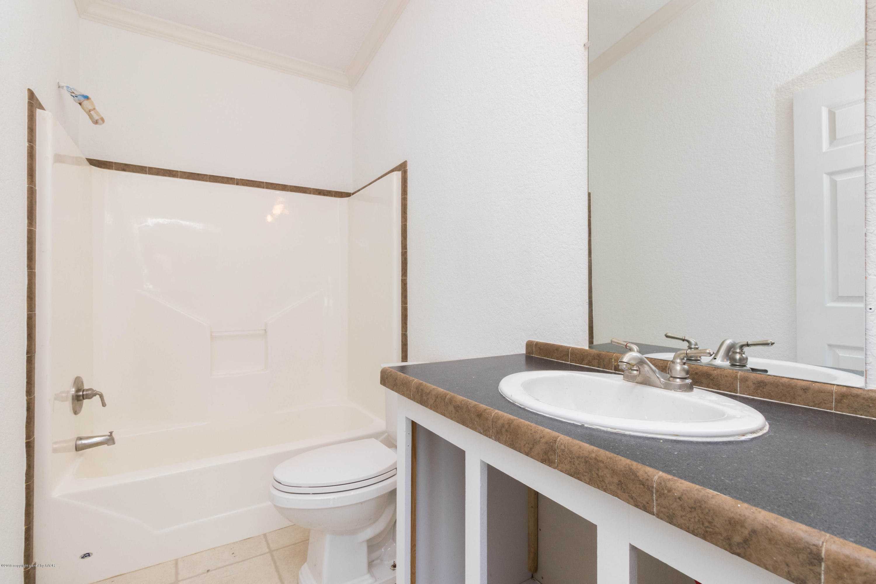 5015 Arden Road Amarillo, TX 79110 - Photo 24 of 38 a bathroom with a granite countertop sink toilet and shower
