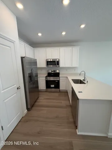 a kitchen with a sink a refrigerator a stove top oven and cabinets
