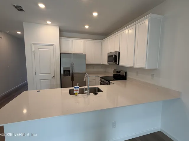 a kitchen with sink refrigerator and microwave