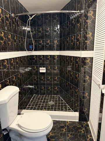 a bathroom with a toilet and a shower