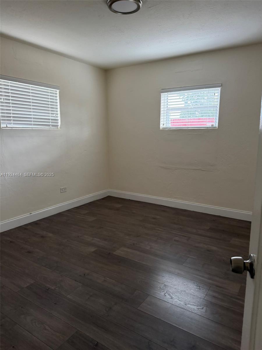 791 East 21st Street Hialeah, FL 33013 - Photo 14 of 19 an empty room with wooden floor and windows