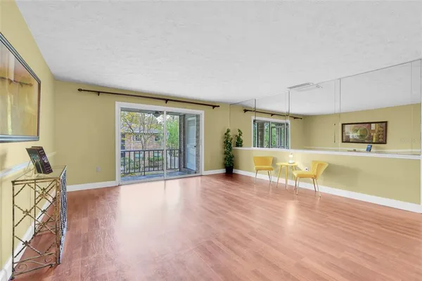 a view of a livingroom with wooden floor and furniture
