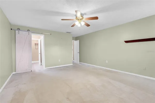 an empty room with closet and fan