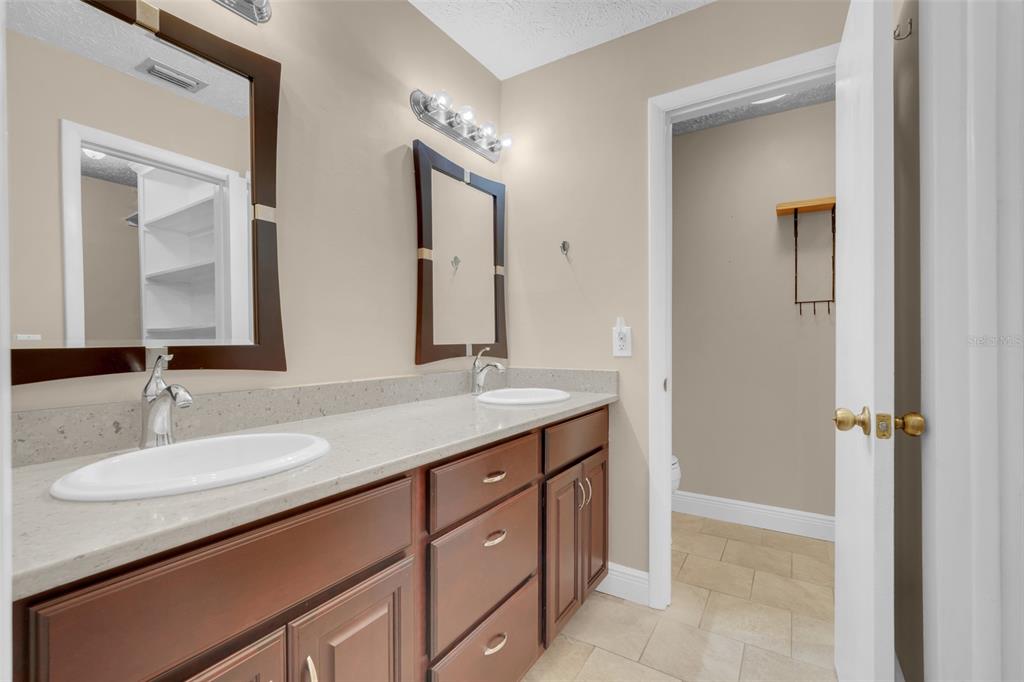 4224 Lake Underhill Road, Unit 8B8 Orlando, FL 32803 - Photo 20 of 47 a bathroom with a granite countertop sink vanity and mirror