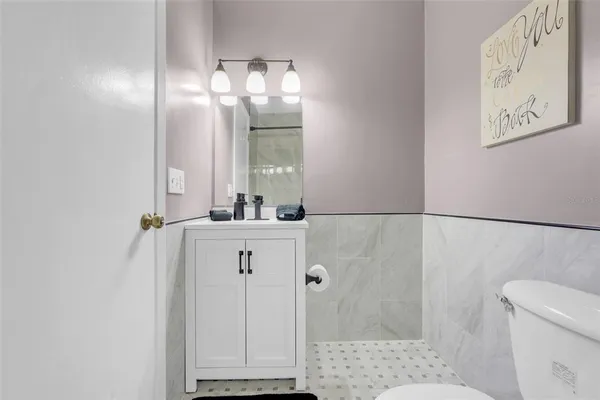 a bathroom with a sink a toilet and shower
