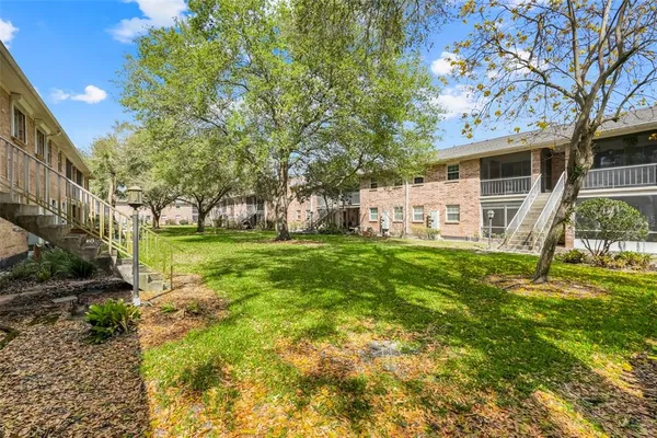 a view of a house with backyard and a tree