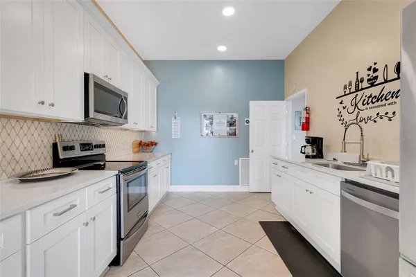 a kitchen with stainless steel appliances granite countertop a refrigerator sink and white cabinets