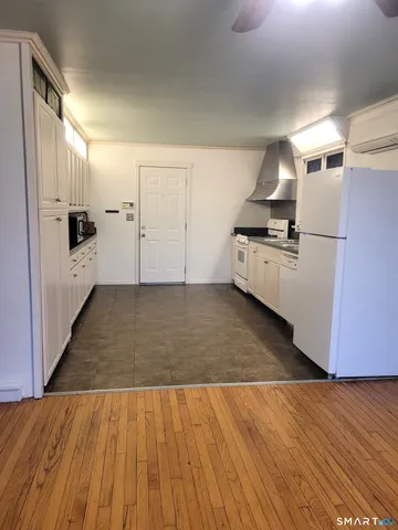 an empty room with wooden floor a fireplace and windows