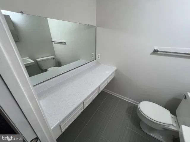 a white toilet sitting next to a bathroom sink