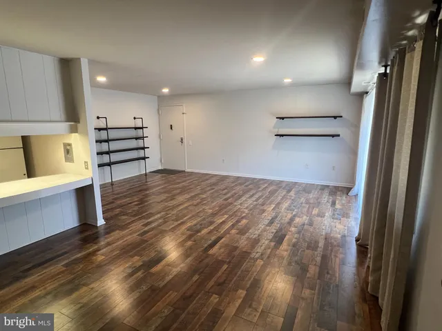 a kitchen view with wooden floor and electronic appliances