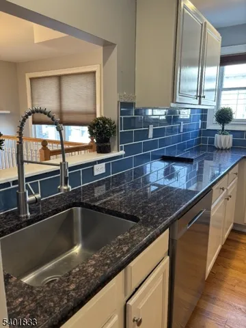 a kitchen with granite countertop a sink and cabinets