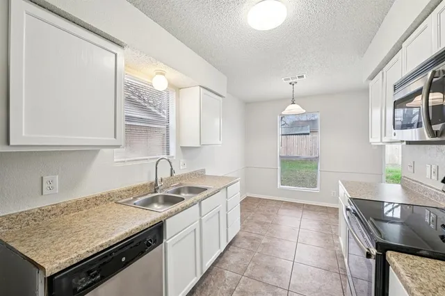 a kitchen with a stove a sink a refrigerator and wooden cabinets